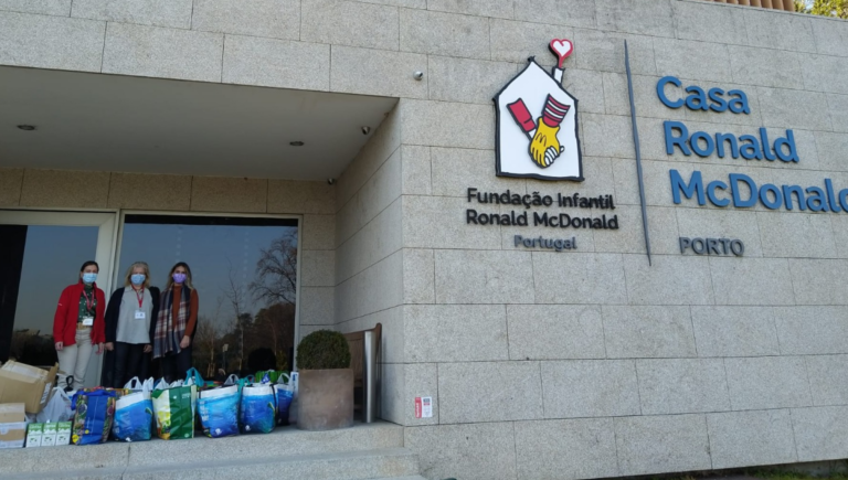 Pessoas com sacos com doações em frente à Casa Ronald McDonald do Porto