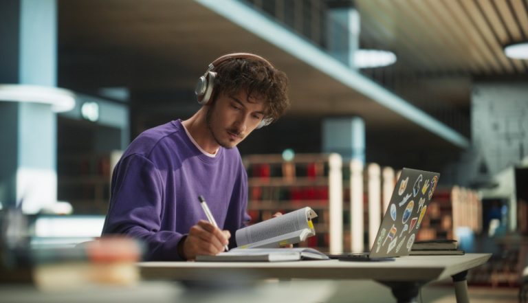 Estudante a estudar com auscultadores e um portátil, representando o conceito de cursos a distância